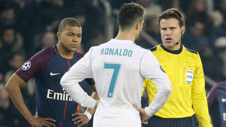 Kylian Mbappé standing with Cristiano Ronaldo