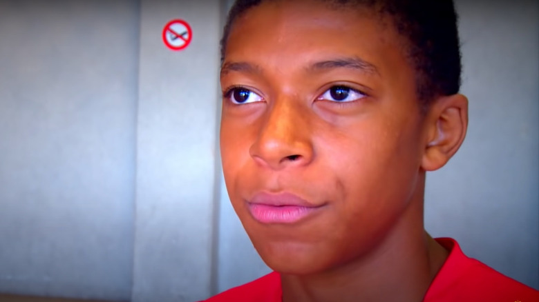 Young Kylian Mbappé in red shirt