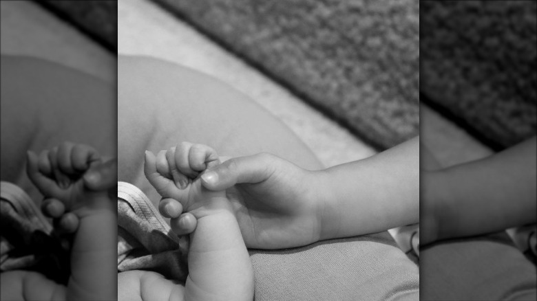 Stormi Webster holding her little brother's hand