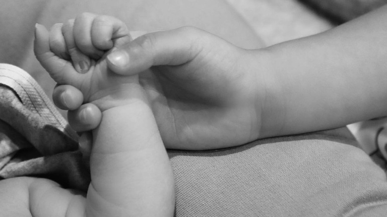 Stormi Weber holding her little brother's hand