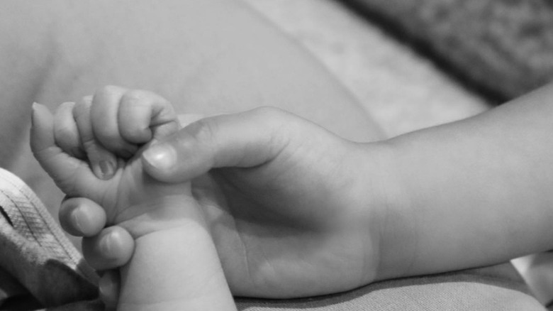 Wolf and Stormi Webster holding hands