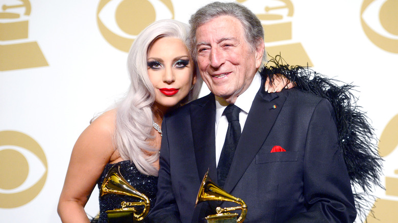 Lady Gaga and Tony Bennett smiling holding two Grammy Awards