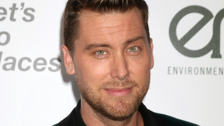 Lance Bass poses in a green velvet jacket