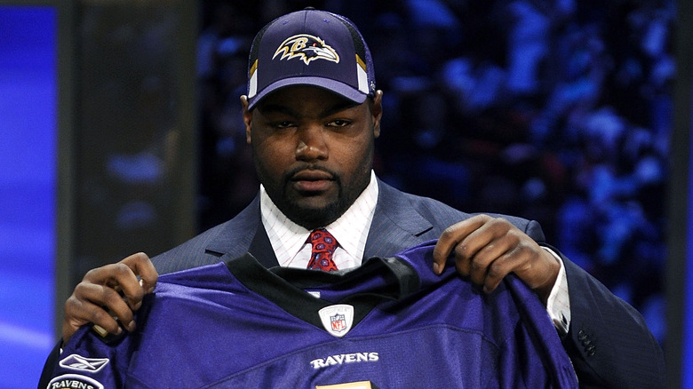 Michael Oher posing with jersey