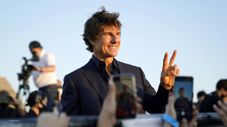 Tom Cruise holding up a peace sign 