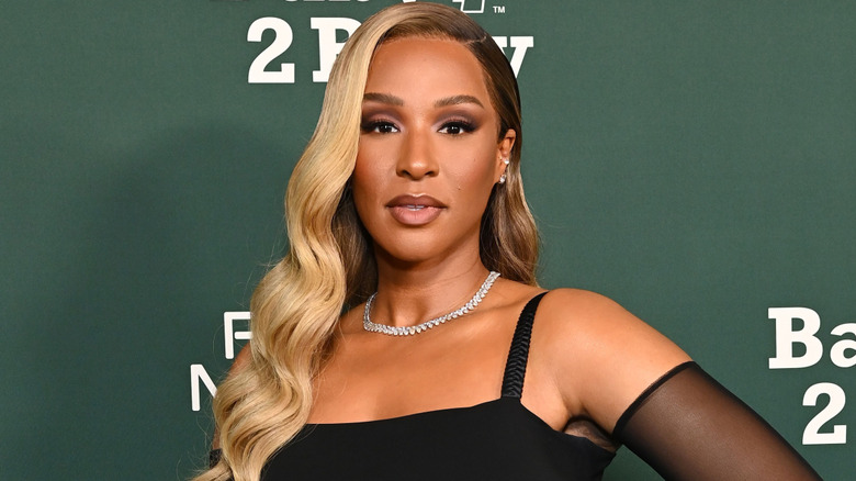 Savannah James posing in a black outfit with a diamond necklace