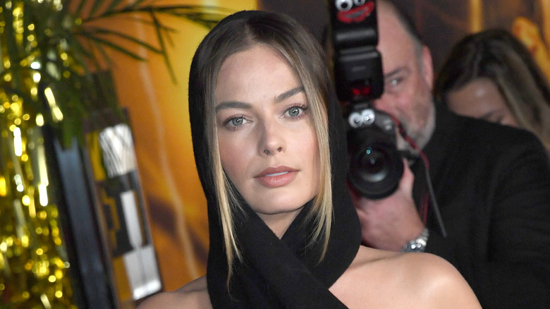 Margot Robbie posing in hooded scarf