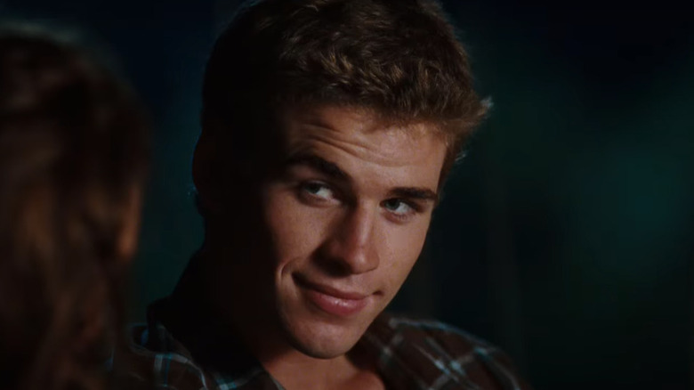 Liam Hemsworth looks away and smiles