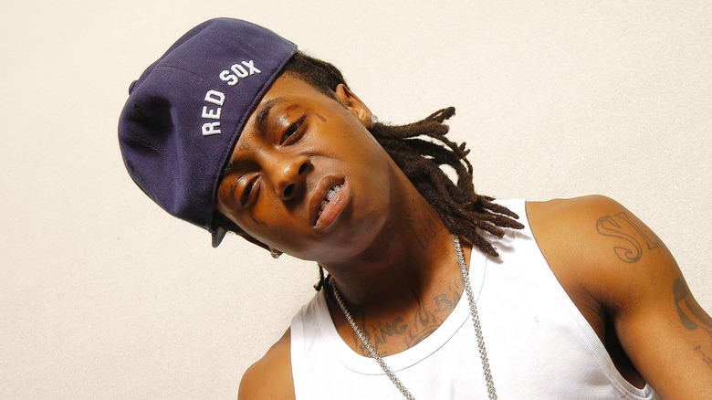 Lil Wayne wearing red sox baseball cap and white vest