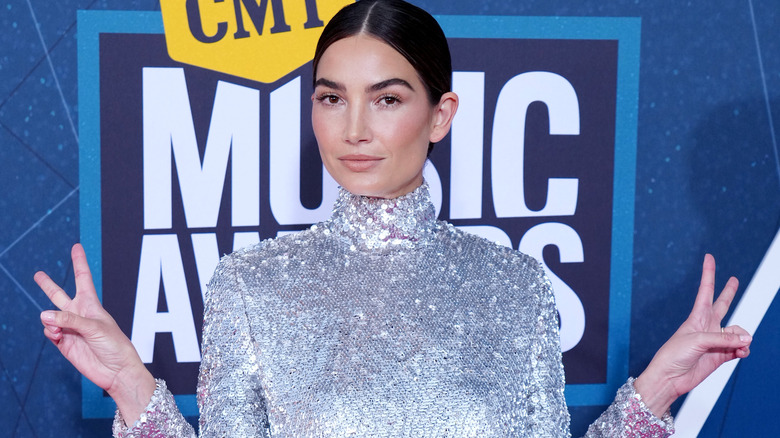 Lily Aldridge holding peace signs