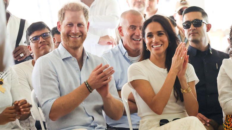 Meghan Markle and Prince Harry clapping together.