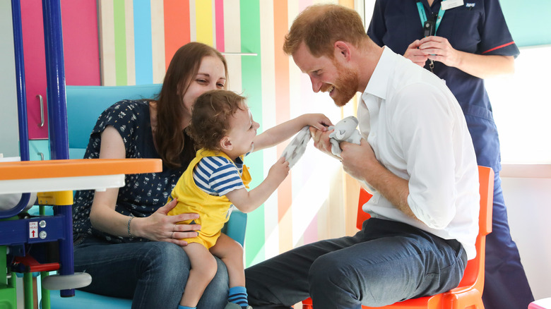 Prince Harry and Noah Nicholson playing with toy giraffe at the Sheffield Children's Hospital.