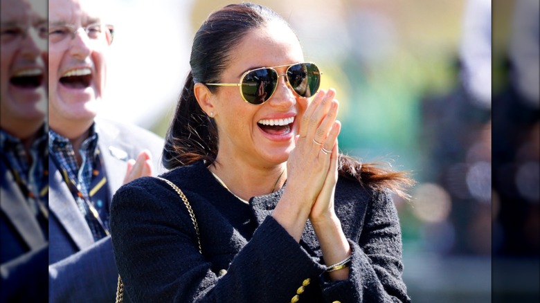 Meghan Markle clapping and laughing.