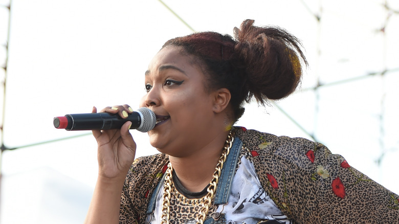 Lizzo holding microphone, singing