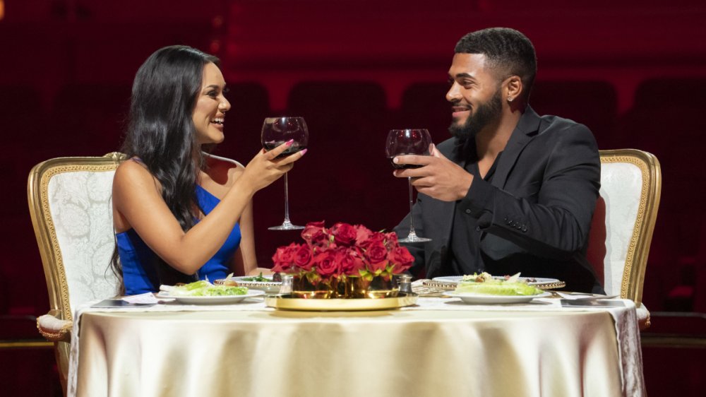 Love Island USA's Cely and johnny smiling and toasting with wine