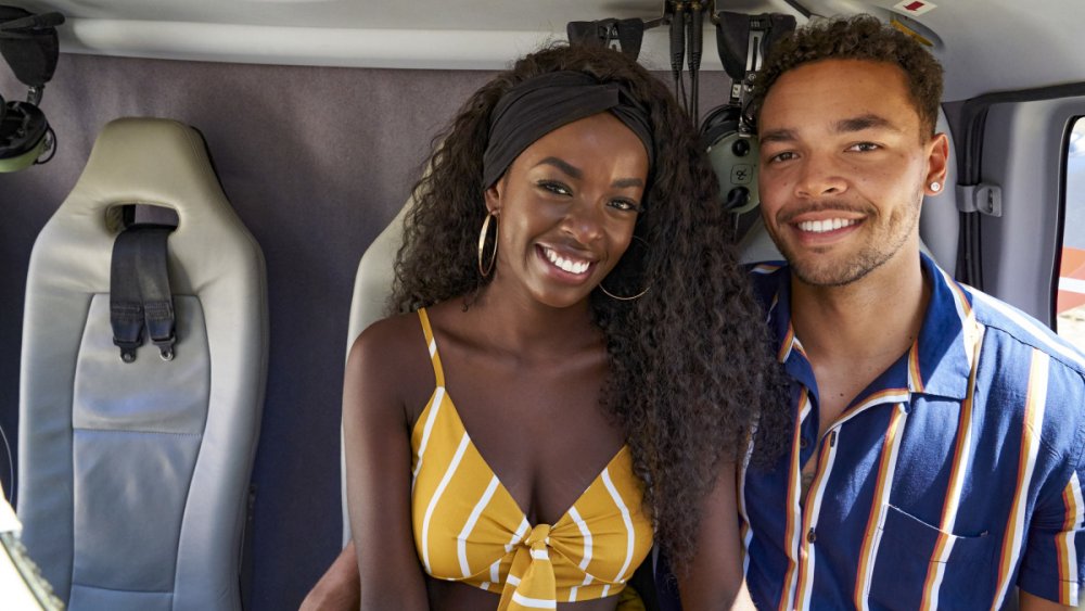 Love Island's Justine and Caleb smiling in a helicopter