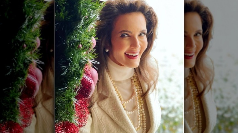 Lynda Carter smiling next to Christmas tree