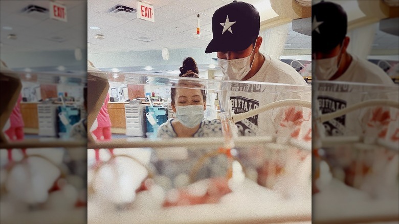 Taylor Dye and Josh Kerr stare at their daughter in the NICU