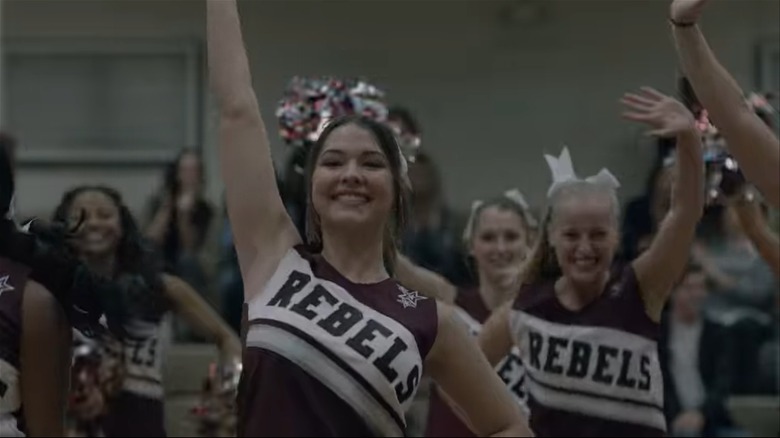 Madelyn Cline as Chloe smiling while cheerleading