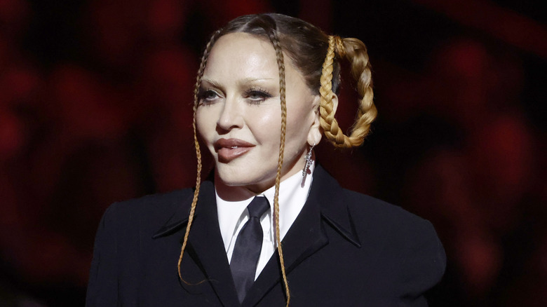 Madonna with her hair in looped braids and a black suit