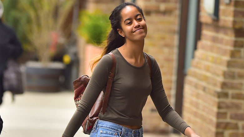 Malia Obama wearing a green long-sleeved shirt and jeans