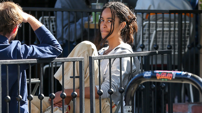 Malia Obama wearing a blue jacket and plaid striped collared shirt