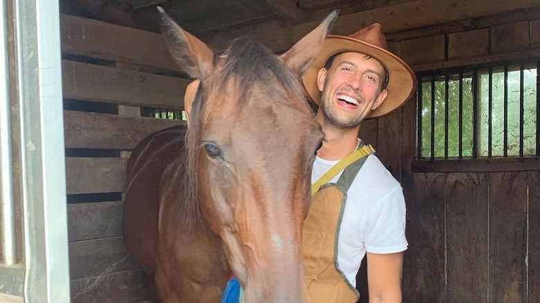 Ryan Fischer posing next to horse 