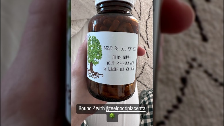 Mandy Moore holds a bottle of her placenta pills