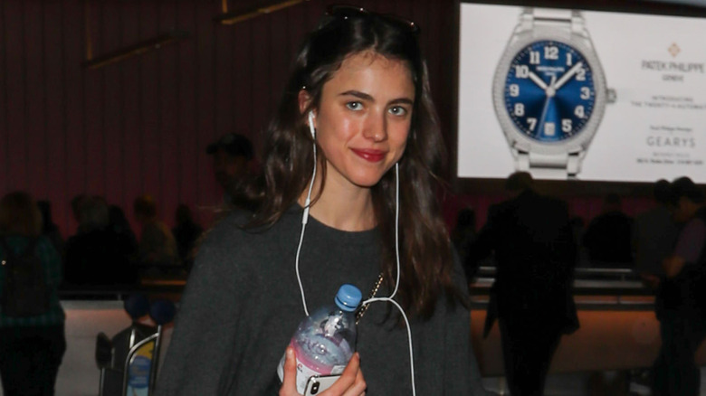 Margaret Qualley smiles for paparazzi at LAX.