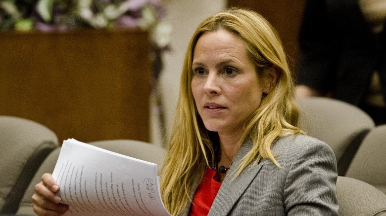 Maria Bello holding papers