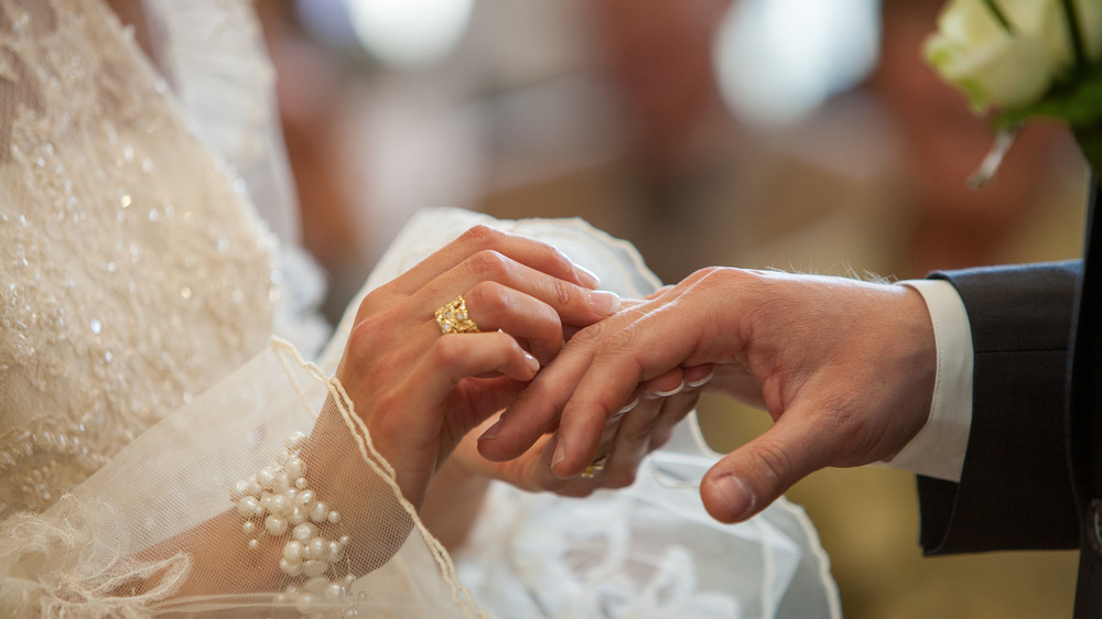 A couple at their wedding exchanging rings