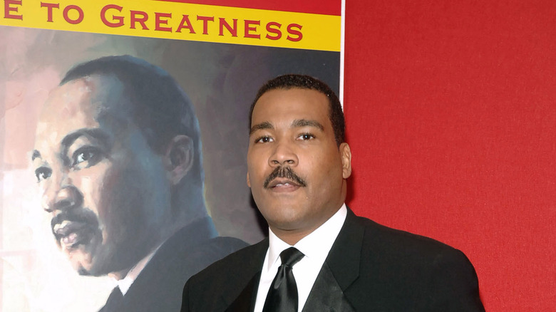 Dexter Scott King stands in front of Martin Luther King Jr. poster