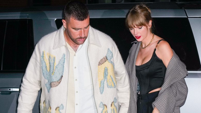 Travis Kelce and Taylor Swift looking down