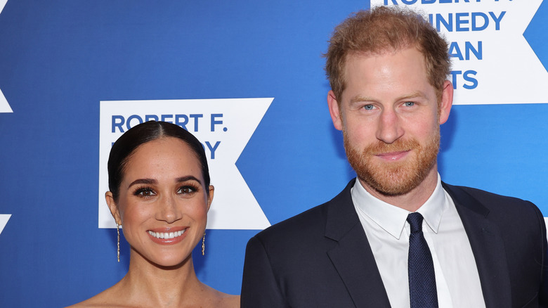 Meghan Markle and Prince Harry smiling at red carpet event