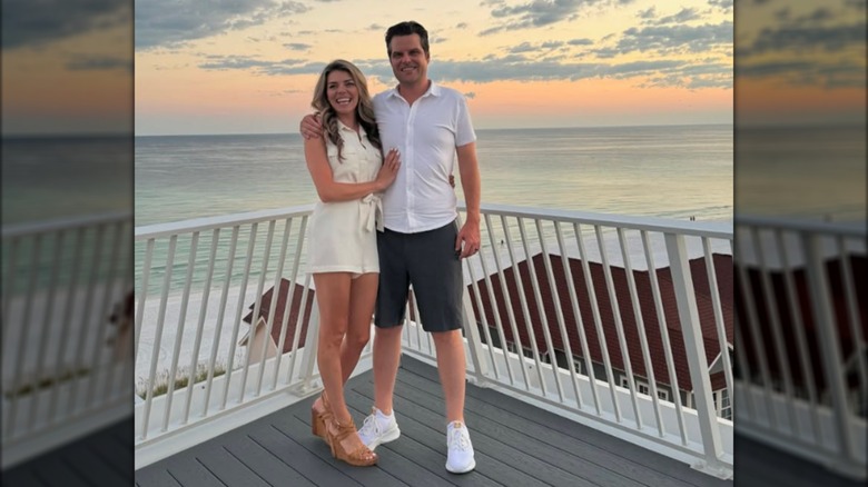 Ginger and Matt Gaetz posing on a balcony overlooking water