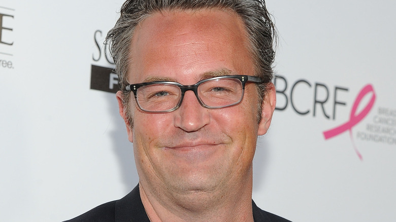 Matthew Perry smiling with glasses on
