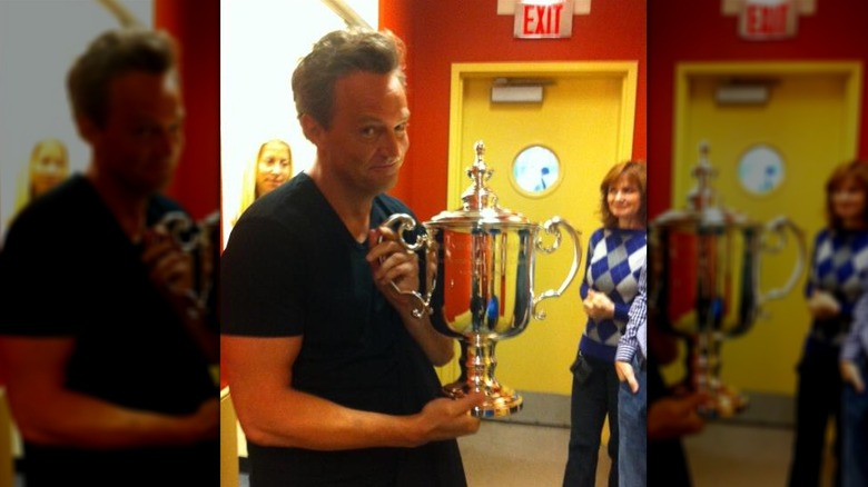 Matthew Perry holding trophy at the U.S. Open