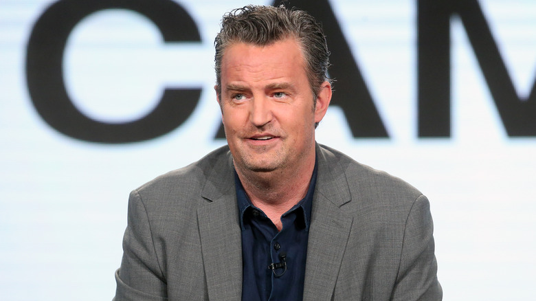 Matthew Perry wears a grey jacket