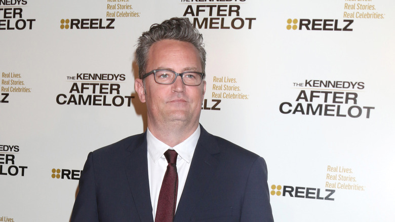 Matthew Perry navy suit glasses