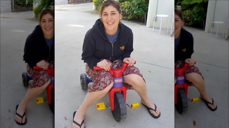 Mayim Bialik playing on son's tricycle