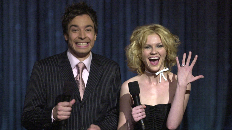 Jimmy Fallon and Kirsten Dunst smiling with microphones