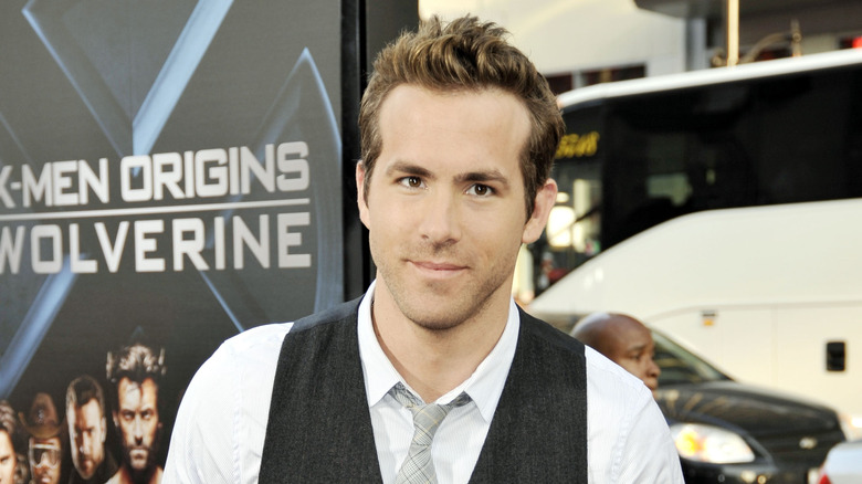 Ryan Reynolds wearing a grey vest, white collared shirt, and a light grey tie