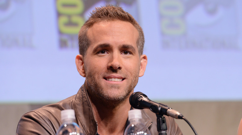 Ryan Reynolds wearing a brown leather jacket at Comic Con panel