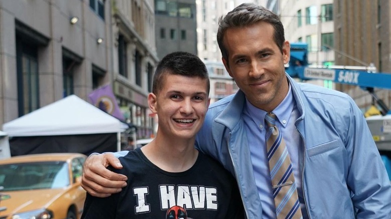 Ryan Reynolds posing with a Make-A-Wish Foundation recipient