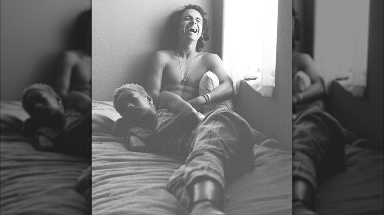 Willow Smith and Moisés Arias take a photo together on a bed 