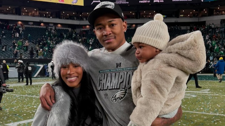 Mya Danielle, DeVonta Smith, and their daughter posing