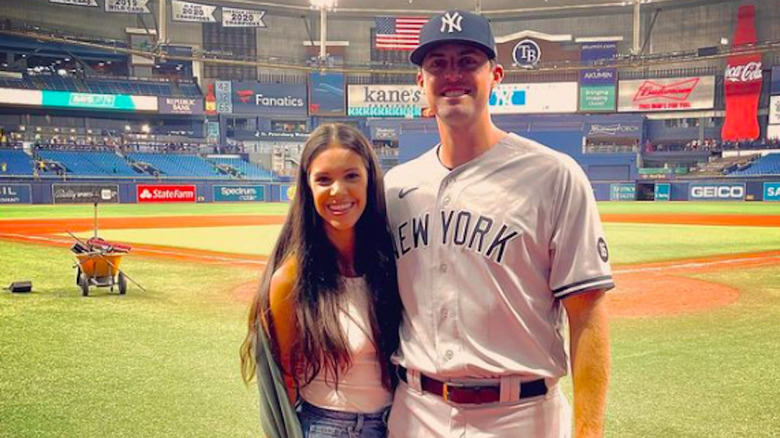 Clay Holmes posing in Yankee Stadium with wife Ashlyn