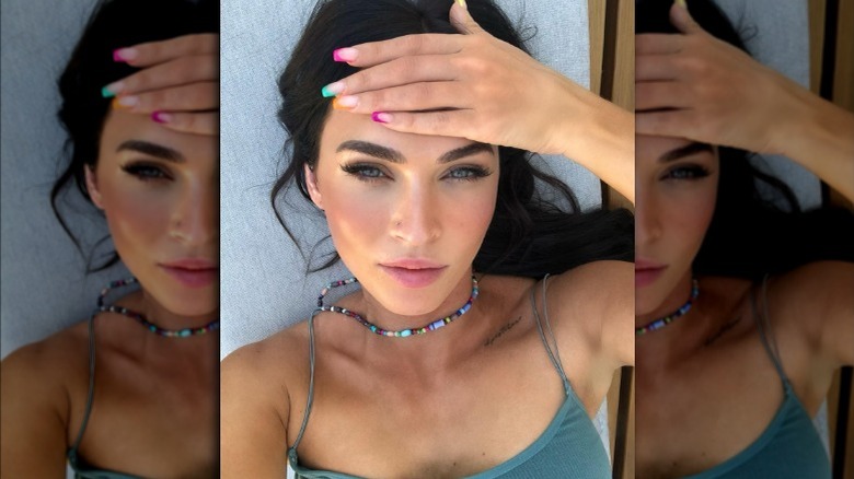 Megan Fox with rainbow-colored fingernail tips