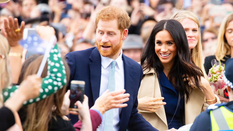 Prince Harry and Meghan Markle in a crowd of fans