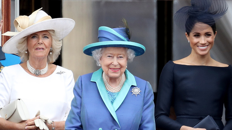 Queen Elizabeth II between Camilla Parker Bowles and Meghan Markle